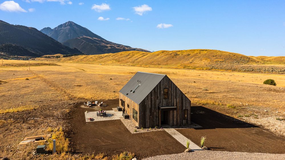 Aerial view of the house on its open acreage with the Absaroka peaks behind