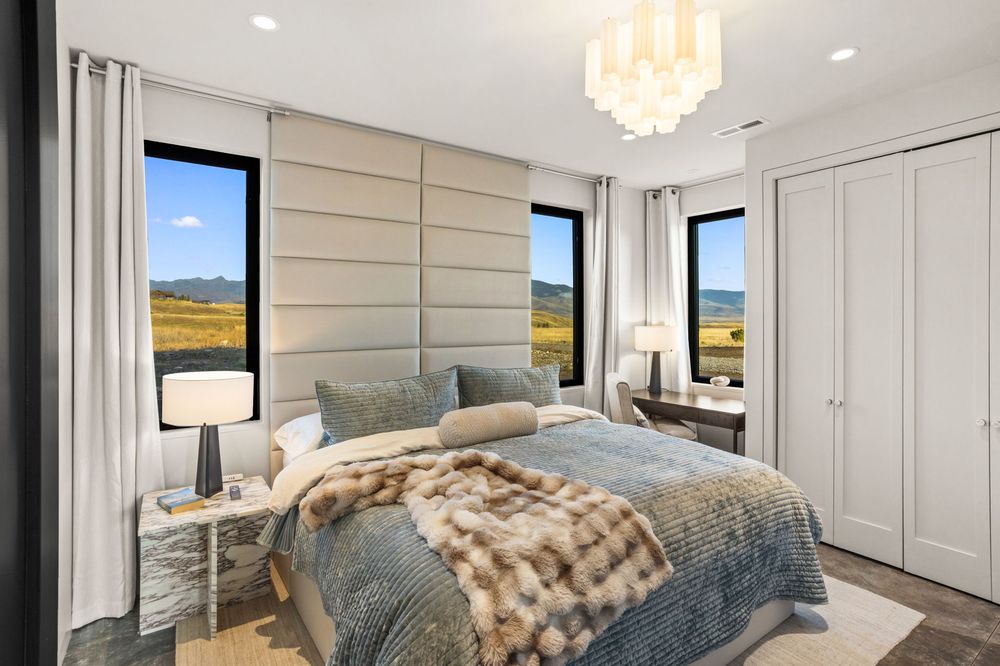 King bedroom with an upholstered headboard and a window onto the valley