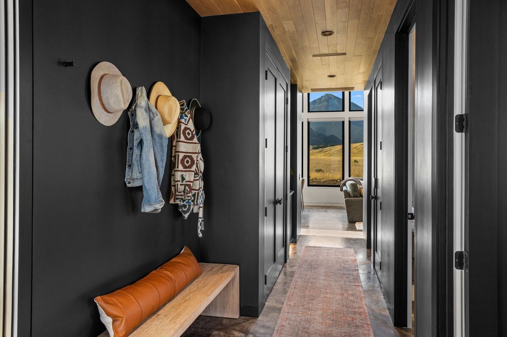 Entry hall with a bench and coat hooks, the front door open to the valley
