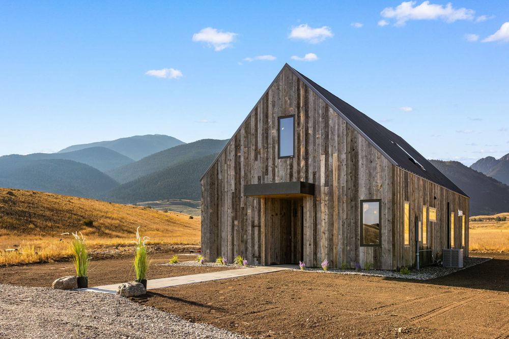 The front of the house, dark weathered timber cladding with a pitched roof