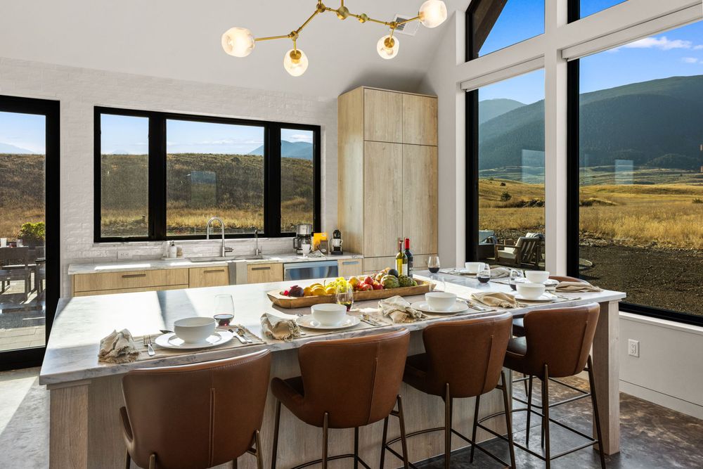Kitchen island with leather stools in front of the glass wall