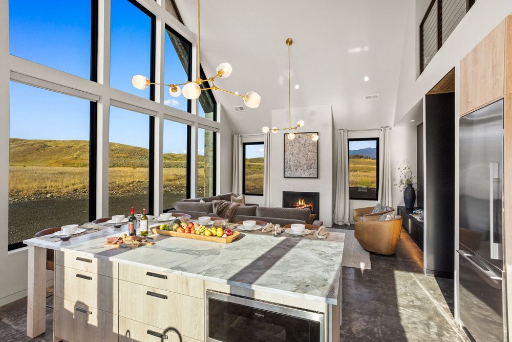 Marble kitchen island with the loft railing above and the sofa beyond