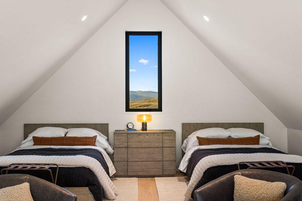 Loft sleeping area with two queen beds under the vaulted ceiling